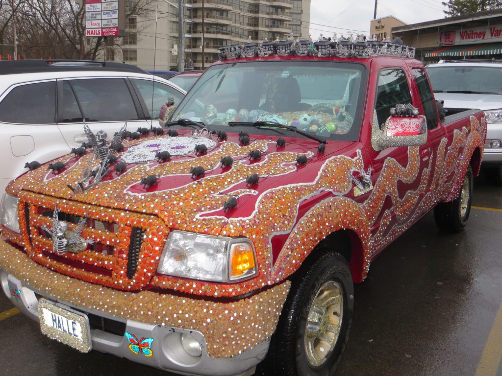Another red pick up truck bedazzled with rhinestones skulls and rats all over exterior.