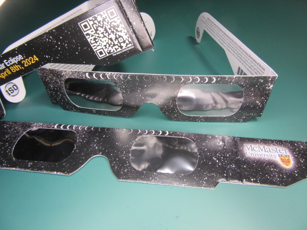 Examples of cardboard eclipse viewing glasses that McMaster University is giving away.