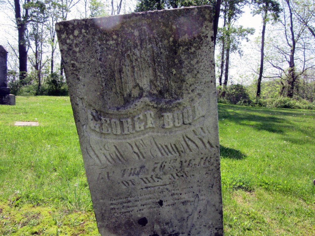 Weathered grave stone of George Book.