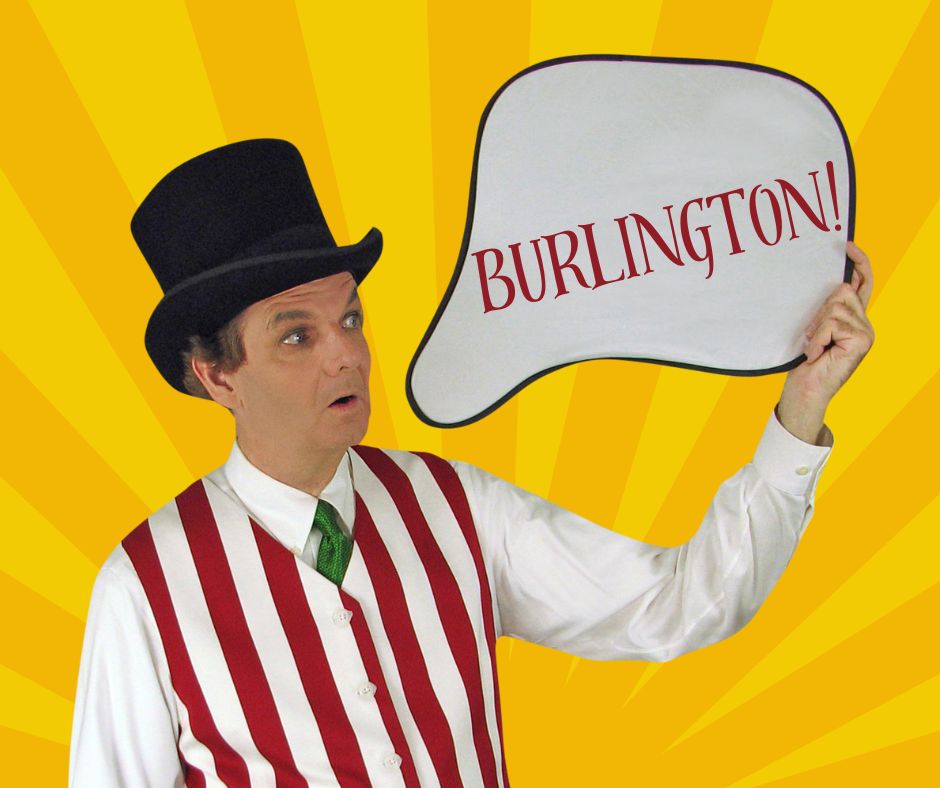 Owen holding a thought bubble style sign that reads Burlington!