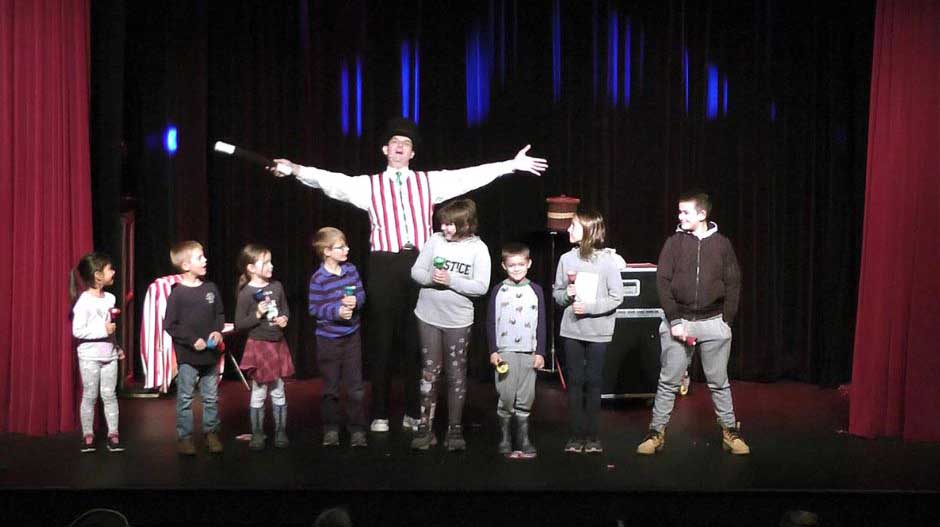 Magician Owen assisted by 8 children on stage for his bell choir routine.