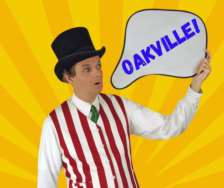 Magician Owen holding a thought bubble style sign which reads Oakville.